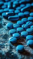 Blue tablets spread across a textured surface in a dimly lit environment photo