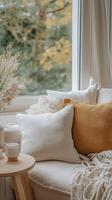 Cozy living room corner with decorative pillows and autumn scenery photo
