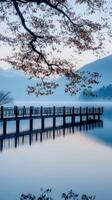 Serene wooden pier reflects on tranquil lake surrounded by mountains photo