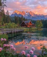 Scenic mountain cabin at sunset reflecting in tranquil lake photo