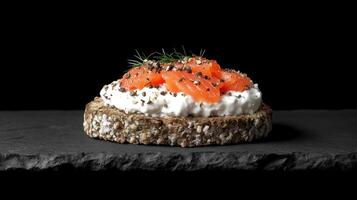 Savory rye bread topped with smoked salmon and cream cheese on black stone photo