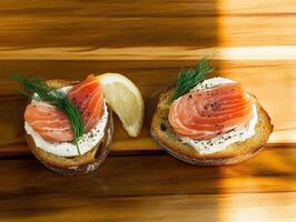 Delicious smoked salmon on crispy bread with lemon and dill garnish photo