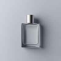 Clear glass perfume bottle on smooth gray surface with silver cap photo