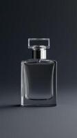 A clear glass perfume bottle stands upright against a dark backdrop photo