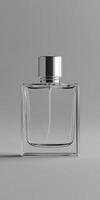 Clear glass perfume bottle with silver cap on gray background photo