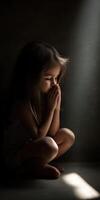 Child in quiet contemplation with light streaming through dark space photo
