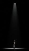 Light breaks through darkness highlighting a solitary figure in a performance photo