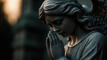 Stone angel figure praying amidst soft twilight glow in quiet setting photo