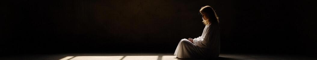 Woman seated in contemplative pose in dimly lit space during evening hours photo