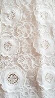 Intricate white lace fabric with floral patterns for crafts and fashion photo