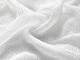 Delicate white mesh fabric displaying intricate patterns under soft lighting photo