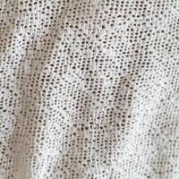 Handcrafted white knitted fabric showcasing intricate patterns and textures photo