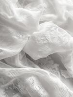 Delicate white fabric with intricate lace details draping softly photo