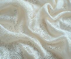 Soft white lace fabric draped elegantly on a surface in natural light photo