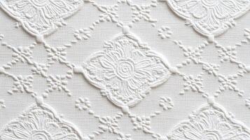 Intricate white embroidered fabric pattern with floral designs and textures photo