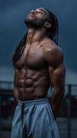 Muscular man posing confidently outdoors under dramatic sky photo