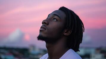 Young man gazing at a colorful sunset over a city skyline photo