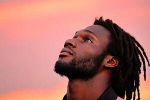 Man gazes upward at colorful sunset sky with contemplative expression photo