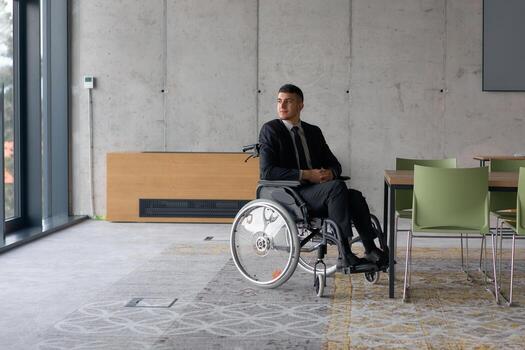 A director in a wheelchair sitting alone in an empty office, deeply reflecting on business strategies and decisions, contemplating the path forward with focused determination. photo