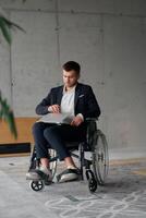 A director in a suit sitting in a wheelchair, using a ball in a modern office, embodying adaptability, focus, and leadership while navigating challenges in the workplace photo