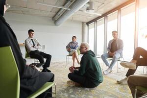 Corporate business team meeting with a manager or coach. Group of happy diverse, multiracial people sitting in a circle photo