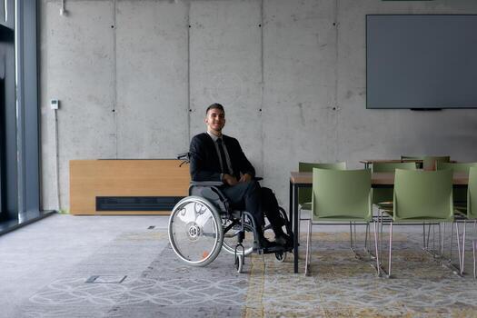 A director in a wheelchair sitting alone in an empty office, deeply reflecting on business strategies and decisions, contemplating the path forward with focused determination. photo