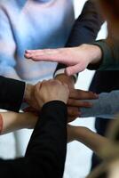 A top view of business people joining hands in a circle, symbolizing unity, collaboration, and shared success in the workplace photo