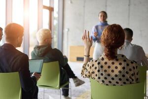 A diverse group of business professionals sits attentively in a modern office, actively participating in a training session led by an instructor, focusing on the latest technological advancements in photo