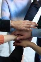 A top view of business people joining hands in a circle, symbolizing unity, collaboration, and shared success in the workplace photo