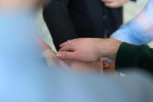 A top view of business people joining hands in a circle, symbolizing unity, collaboration, and shared success in the workplace photo