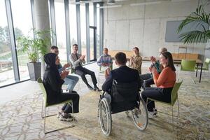 Corporate business team meeting with a manager or coach. Group of happy diverse, multiracial people sitting in a circle photo