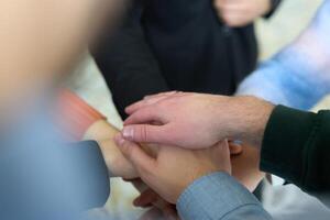 A top view of business people joining hands in a circle, symbolizing unity, collaboration, and shared success in the workplace photo