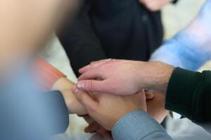A top view of business people joining hands in a circle, symbolizing unity, collaboration, and shared success in the workplace photo