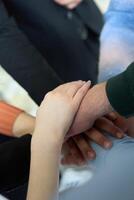 A top view of business people joining hands in a circle, symbolizing unity, collaboration, and shared success in the workplace photo