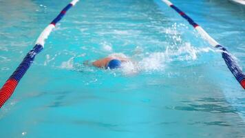 Swimmer splashing in pool lane, Swimmer creating splashes while practicing in a pool lane video