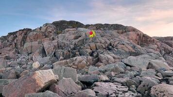 Traveler, dressed in bright yellow raincoat, completes his climb up hill made of piles of boulders. Overwhelmed with joy, he enjoys fresh air and feels free, with his arms stretched out. video
