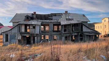 An abandoned wooden apartment building, located in middle of village in northern climate, is slowly falling apart, having been left behind by its former inhabitants. video