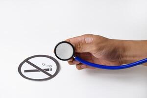 Stethoscope held by hand examining paper about smoking prohibition photo