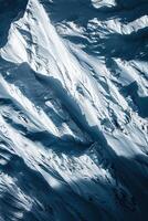 vertical image aerial view of snow-covered mountain range, abstract natural textured background with bright sunlight photo