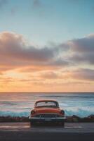 vertical image back view of a red retro car on a seashore with sun rising on a background photo