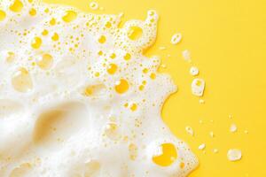 top view white soap foam and bubbles on bright yellow background with copy space photo