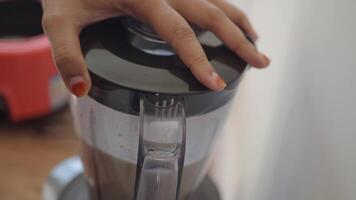 Carefully Hand Placing the Lid on the Blender for Smoothie Preparation video