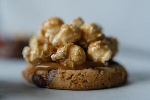 Close up of homemade american traditional chocolate chip cookie with caramel popcorn topping. On white background. photo