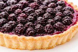 Closeup view of a sumptuous blackberry tart with glistening berries on top, perfectly nestled in a flaky crust. Ideal for a delightful gathering or celebration photo
