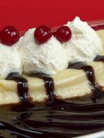 This delightful Bavarian cream dessert, layered on a glossy plate and drizzled with rich chocolate sauce, features fluffy cream puffs and sweet cherries on top. Perfect for dessert lovers photo