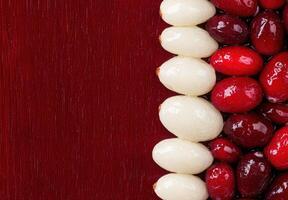 Close up of white and red berries on a dark red background photo