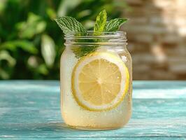 Refreshing lemonade in mason jar with lemon and mint photo