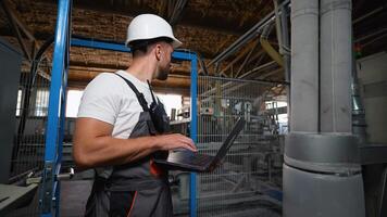 Engineer programmer checks the operation of a conveyor on industrial factory video