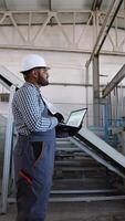 Indian engineer checks the operation of a conveyor on window factory video
