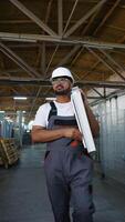 Indian worker walks with a window frame in a window factory near conveyor video